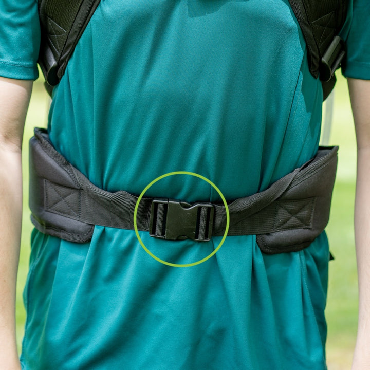Person wearing a green shirt with a black belt and backpack, focusing on the buckle.
