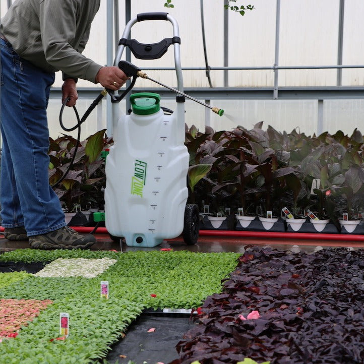 man spraying trays of plants with 9-gallon sprayer