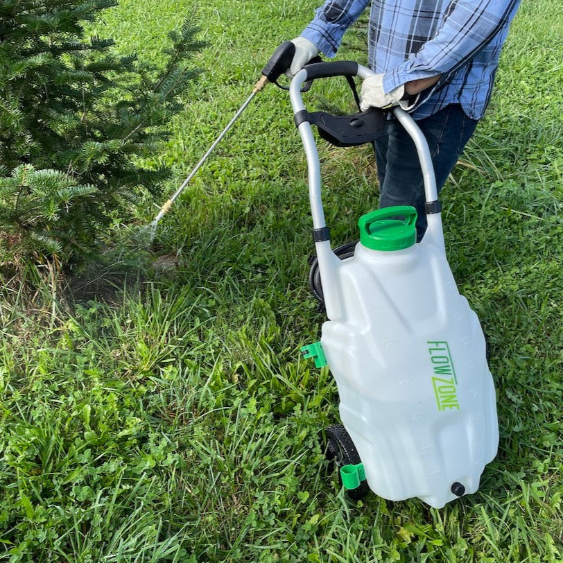 spraying weeds at the base of fir tree with 9-gallon sprayer