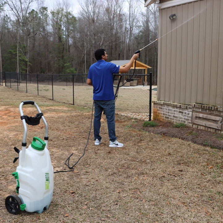 man spraying siding of house with 9-gallon sprayer
